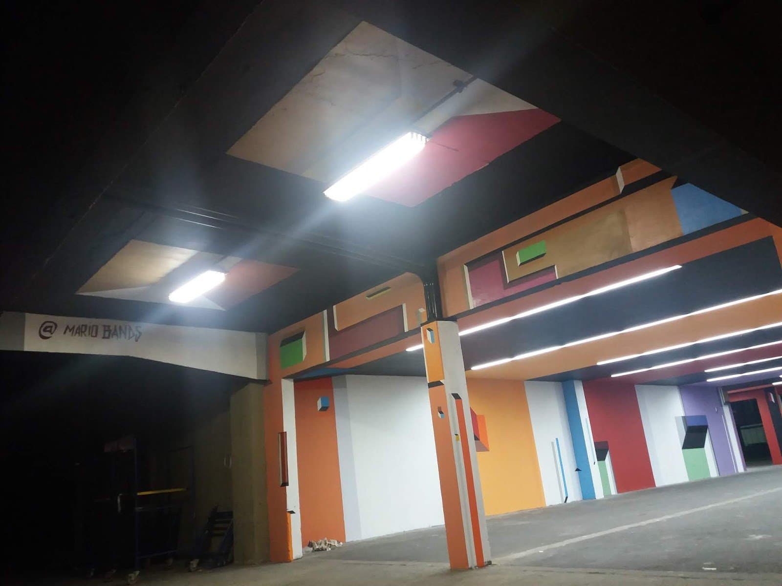 Pintura geométrica de Mario Bands atravessando paredes e quinas no interior do Pavilhão das Artes